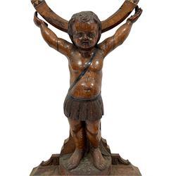 Victorian carved oak gong stand in the form of a Cherub supporting a circular walnut frame with central brass gong, on shaped walnut plinth with beater, H131cm 