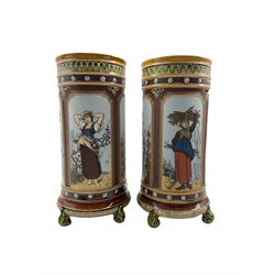 Pair of Mettlach cylindrical stoneware vases decorated with panels of female figures in pastoral landscapes depicting the four seasons by Christian Warth, beaded and floral borders, raised on four acanthus leaf feet, stamped factory marks and numbered 1462, H33.5cm 