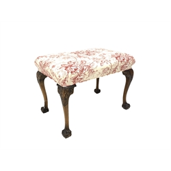20th century Chippendale style walnut footstool, the top upholstered in red floral and ivory linen, the cabriole supports headed by acanthus leaf carving and terminating in ball and claw feet