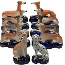 Group of 19th century Staffordshire inkwells, eight modelled as recumbent Greyhounds, two with sponged decoration, all on blue oval bases, two further inkwells modelled as a seated Greyhounds, together with a model of a seated Dalmatian, L16cm max (10)