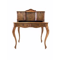 Late 19th century figured walnut Bonheur de jour, scrolled and arched raised back with three cupboards, serpentine moulded main section fitted with two drawers, raised on cabriole supports 
Provenance: This item is thought to have belonged to Lord Londesborough, being sold at auction in the early 20th century 