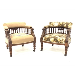 Pair late Victorian tub shaped armchairs, curved spindle gallery supporting upholstered backs, carved s scroll terminals with relief floral carved supports, on collar turned supports, upholstered seats, each support with double wheel brass and ceramic castors, W63cm, seat depth - 60cm