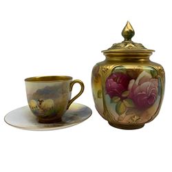 Royal Worcester coffee cup and saucer by Harry Davis, the cup painted with sheep in a highland landscape, the saucer signed H Davis with puce printed marks beneath and date codes for 1915 together with pot pourri vase and cover painted with roses and signed M Hunt with printed puce marks beneath and date code for 1926 (2)