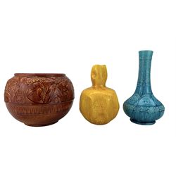 Burmantofts Faience oxblood-glaze jardiniere, decorated in low relief with panels of flowers, model no. 549, ochre glaze dimple vase, model no. 990 and turquoise bottle vase no. 1612, all having impressed factory marks beneath, H26cm (3)