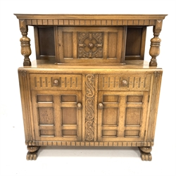  Early 20th century carved oak court cupboard, panelled door to top over two drawers and two panelled cupboards enclosing shelves, raised on hairy paw supports, W125cm, W132cm, D52cm  