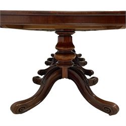 Early Victorian mahogany extending triple pillar dining table, rounded rectangular top with plain skirt, triple turned pedestals each with four splayed supports, lapped carvings to knees and scroll carved terminals with recessed castors, two additional leaves