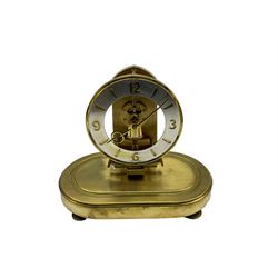 Schatz - German 20th-century battery operated mantle clock, with an oscillating pendulum under an oval glass dome, base with fitted battery compartment and pendulum lock, visible skeleton movement within a white chapter ring with brass baton markers, hands and Arabic numerals.

