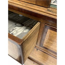 Late Georgian oak press, mahogany banded frieze over two panelled doors enclosing two shelves, two short and two long drawers under, raised on turned supports W131cm, H210cm, D51cm