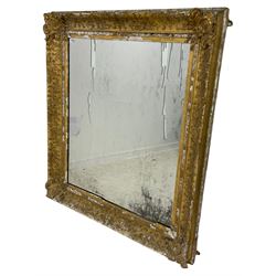 19th century giltwood and gesso wall mirror, the frame decorated with trailing foliage and floral cartouches, plain mirror plate