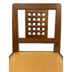 Mouseman - set four oak dining chairs, lattice carved back, upholstered in tan leather with studded band, the octagonal front supports carved with mouse signatures, by the workshop of Robert Thompson, Kilburn