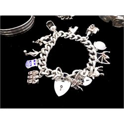 Silver jewellery including curb link bracelet with heart locket clasp and eleven charms including poodle, cherub and three wise monkeys, dragon design bangle, bright cut buckle bangle and one other hinged bangle 