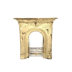Victorian cast iron fire surround, mantel shelf over scrolled motif leading to a central mask and arched moulded aperture, aperture width 35cm