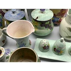 A collection of Radford hand-painted pottery to include a trio of Crocus shaped vases, preserve jars, two butter dishes, two tall vases, ashtray, three piece cruet on stand, basket etc (23)