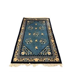 Chinese blue ground rug, field decorated with foliate medallions, triple band with central Greek key design (242cm x 151cm); Chinese red ground rug with central flower decorated lozenge and repeating floral decoration (181cm x 124cm) (2)