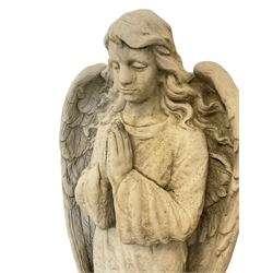 Composite stone garden figure modelled as a winged praying angel, raised on a circular plinth