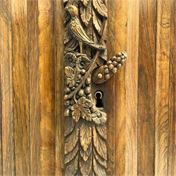 17th century Dutch rosewood and oak ‘Zeeuwse Kast’ or cupboard, projecting cornice carved with three putti masks, the uprights carved with lion masks over ribbons, flower heads and foliage, enclosed by four geometric panelled doors, lower central upright carved with flower head over foliate ribbon with bird among foliage, the escutcheon hidden by swivel berry carved cover, interior fitted with shelves, two drawers and shallow hinged cupboard, on two large turned and ebonised feet