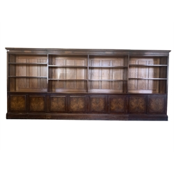 Late Victorian country house mahogany, walnut and oak dwarf breakfront bookcase, projecting cornice over frieze inlaid with figured walnut panels over eight open adjustable shelves, four fielded panelled double cupboard doors under enclosing four fixed shelves, raised on plinth base