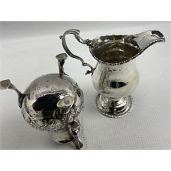Early George III silver baluster cream jug with C scroll handle H11cm, marks rubbed but circa 1774 and another with later embossed decoration 5.9oz (2)