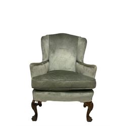 Victorian wingback armchair, upholstered in green fabric, raised on cabriole supports 