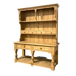 Victorian style pine dresser, the projecting cornice over two tiered plate rack with four spice drawers over base with two long drawers and pot board base, raised on turned and block supports W165cm, H210cm, D63cm