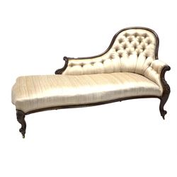 Victorian mahogany chaise longue, moulded crest rail with scrolled and floral carved arm terminals, the buttoned back and serpentine seat upholstered in faded silk, raised on scrolled supports terminating in brass cup castors L171cm D91cm, H90cm