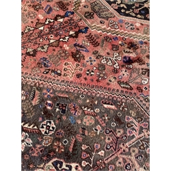  Persian Quashgai red ground rug, decorated with lozenge medallion, stylised foliate and Bucephalus horses, 192cm x 250cm  