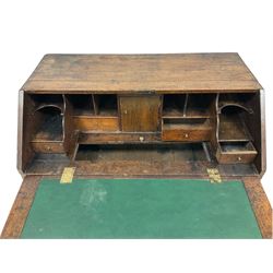 George III oak bureau, the fall-front enclosing fitted interior with inset leather writing surface, lower section with two short and two long drawers with brass handles, raised on bracket feet