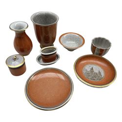 Nine pieces of Royal Copenhagen orange crackle glazed pottery comprising two vases, a small plate decorated with a scene of Rosenborg, reeded vase, cylindrical jar and cover, pedestal bowl and other pieces H15cm max (9)