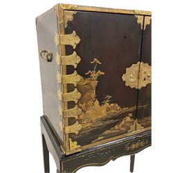 18th century Japanned cabinet on stand, Chinoiserie black lacquered and gilt decoration depicting pagodas within a cliffside waterscape, decorated with trees and birds, the door interiors decorated with overlapping rectangular panels, fitted with a combination of drawers each decorated with similar waterscape scenes, with embossed central lock plate and chased strap hinges, on later black lacquered stand with shaped apron and cabriole supports

Provenance - property of a nobleman 