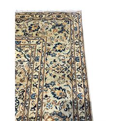 Persian ivory ground rug, central foliate pole medallion surrounded by repeating foliate patterns with interconnected flower heads, the spandrels with indogpo scroll outlines, the main border with stylised plant motifs and six bands 
