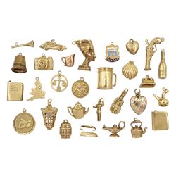 Twenty-nine 9ct gold charms including Moet champagne, shell, classic car, pistol, tankard and map of England