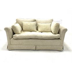 Two seat sofa upholstered in beige fabric, loose cushions, raised on castors, W147cm