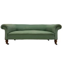 Late Victorian settee, walnut and hardwood framed, upholstered in green lozenge patterned fabric, on ring turned feet with brass and ceramic castors 