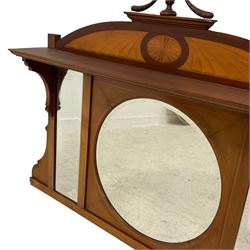 Edwardian inlaid mahogany overmantel mirror, the arched pediment with satinwood fan inlay mounted by turned finial, projecting moulded lintel over circular and rectangular bevelled mirror plates, shaped side brackets