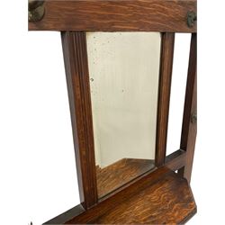 Edwardian oak hallstand, fitted with one bevel edged mirror, surrounded with hooks for hanging over floral tiles and drip tray with two divisions, raised on squared supports 