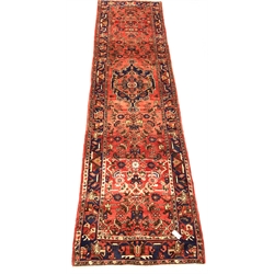 Persian Hamadan runner rug, central medallion on red field, enclosed by guarded border, 370cm x 105cm
