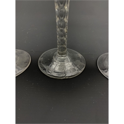 Set of three 18th century wine glasses, the ovoid bowls engraved with flower sprigs on faceted stems and conical feet, H15cm 