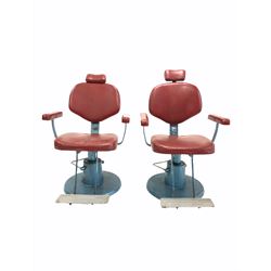 Pair of barbers chairs, with red vinyl upholstered seat and backs, reclining, rise and fall and swivelling on cast metal bases W70cm