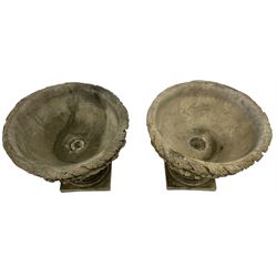 Pair of composite stone garden urn planters, acanthus leaf garland rim over foliate decorated body, stepped foot on square base