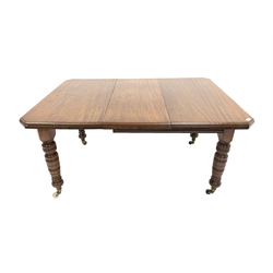 Edwardian mahogany wind out extending dining table, the top with canted corners over turned supports and brass and ceramic castors, one additional leaf 