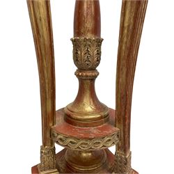 Late 20th century carved beech torchere or floor lamp in the manner of Adams, terracotta bole and gilt finish, three fluted and tapered uprights with mythological bearded faun carved terminals supporting circular top with gadroon moulded underbelly and flower head carved rim, central turned and acanthus carved pedestal support on concave triform base with carved rams head terminals, decorated with trailing bell flower swags and floral cartouches, carved with three hairy paws to each corner, stepped moulded base platform raised on block bracket feet