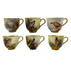 Six Royal Worcester coffee cups and saucers by Albert Shuck and Reginald Austin, the cups painted with birds in a landcape including an Eagle, Heron, Barn Owl, Pigeon and Pheasant, signed A. Shuck, and Peacock signed R. Austin, all on matching landscape painted saucers, with puce printed marks beneath and date codes for 1926, 1933 and 1936 
