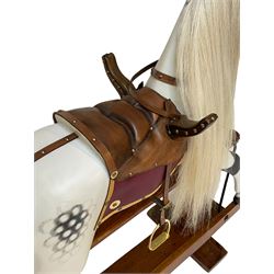 F. Ayres of London - early 20th century dapple grey rocking horse, with leather saddle and brass stirrups, on trestle base with turned pillars, recently restored