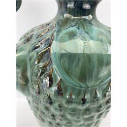 Large Art Nouveau style three handled green glazed vase, of tapering form with three Peacock heads forming the handles, the foot moulded with a border of peackock feathers, H54cm 