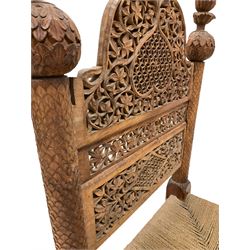 Indian style hardwood chair, profusely carved back panel over string seat 
