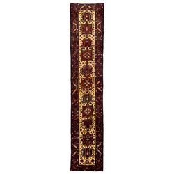 Persian Hamadan ivory ground runner, the field decorated with eleven geometric medallions, stylised flowerhead and geometric motifs, the guarded border decorated with repeating floral motifs