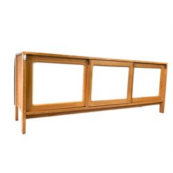 Mid century modern beech and white laminate sideboard, three sliding panelled doors enclosing fixed shelves and four drawers, raised on stile supports 200cm x 49cm, H75cm