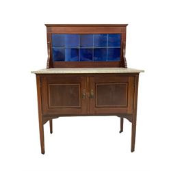 Edwardian mahogany washstand, the blue tiled back and marble top, over two cupboards with satinwood inlay, raised on squared supports, terminating in castors
