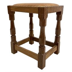 'Oakleafman' oak joint stool, rectangular seat upholstered in tan leather with studded band, on four octagonal supports joined by stretchers, carved with leaf signature, by David Langstaff of Easingwold