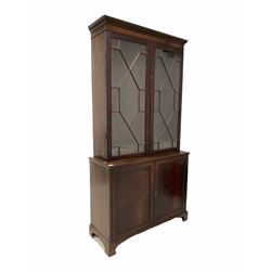 Georgian mahogany bookcase on cupboard, dentil cornice over two astragal glazed doors enclosing three adjustable shelves, two panelled cupboard doors under, raised on bracket supports W103cm, H201cm D40cm